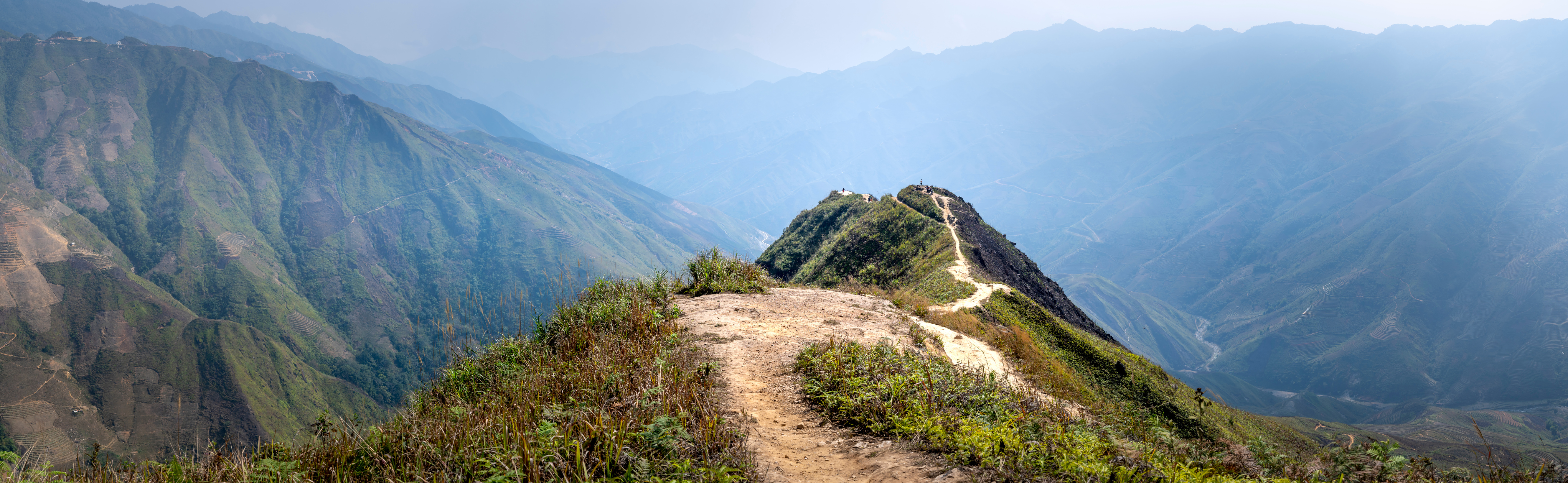 Trail running on hilltop in mountainous valley